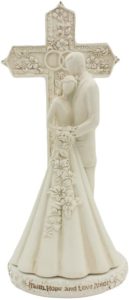 Ivory couple standing in front of an ornate cross