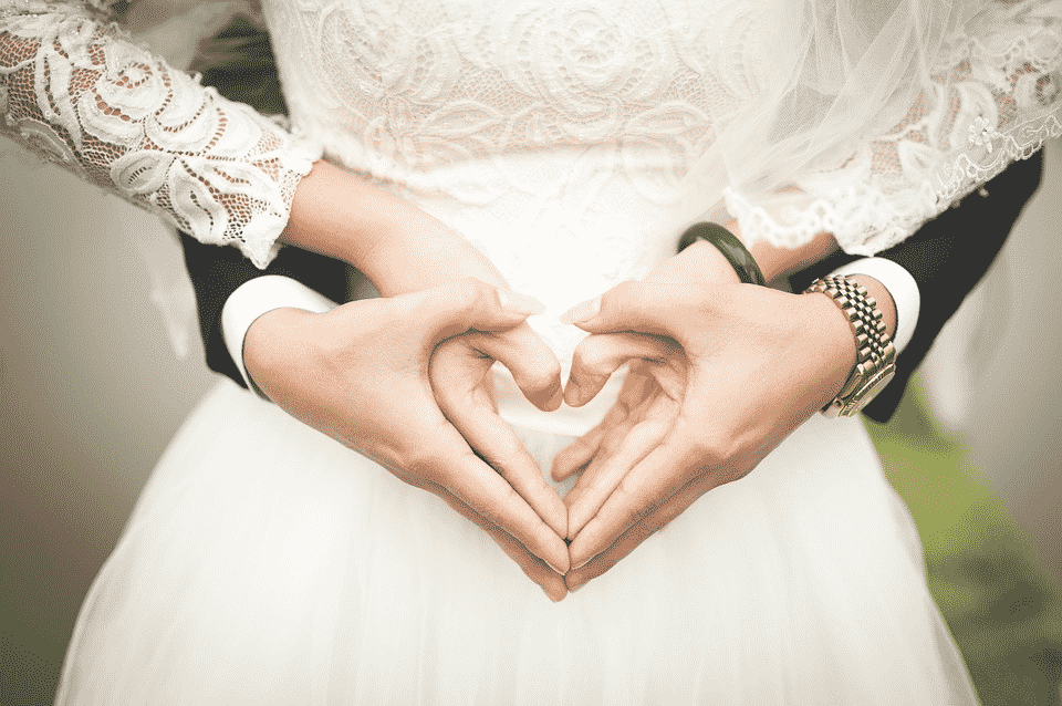 Married couple making heart symbol with their hands