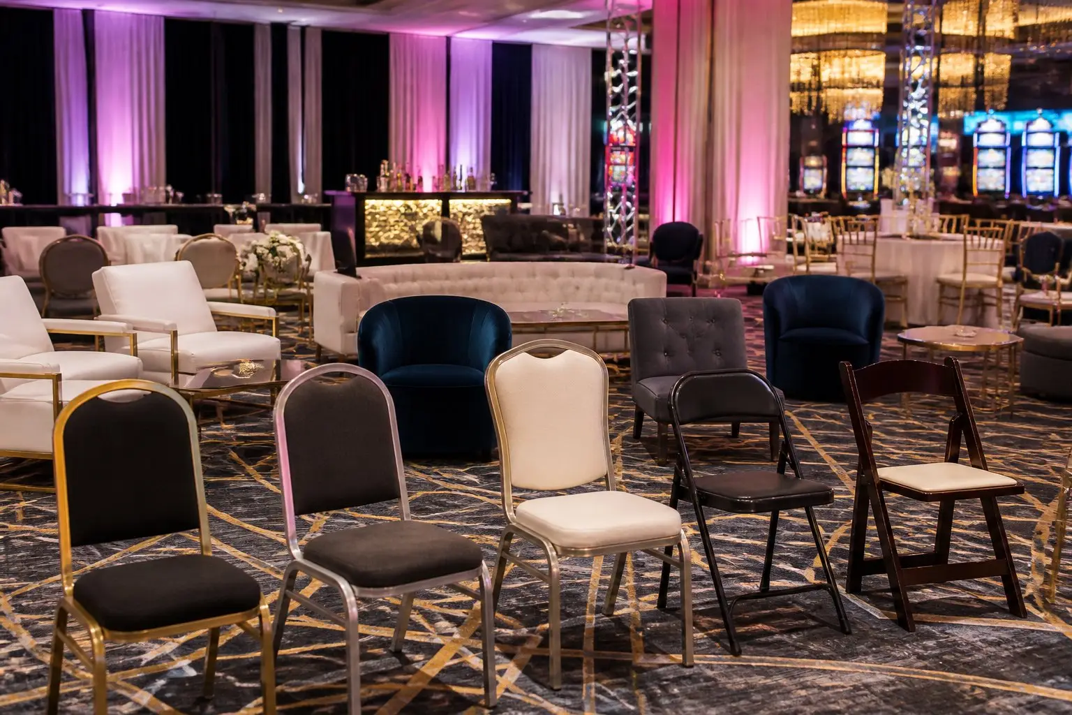 A spacious event room in Las Vegas with various types of chairs arranged neatly, including banquet, lounge, and folding chairs.